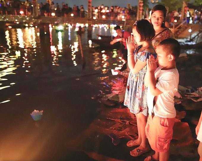 Du khách thả đèn để cầu bình an cho gia đình. Một chiếc hoa đăng làm bằng giấy, kèm đèn cầy bán giá cố định 10.000 đồng - Ảnh: Nguyễn Đông