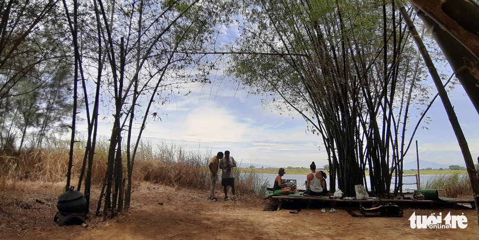 Một gia đình du khách đến tham quan An Nhiên farm ngồi nghỉ mát dưới lũy tre xanh - Ảnh: LÊ TRUNG