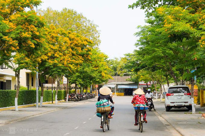 Hai phụ nữ đạp xe bán hàng trên đường Phan Chu Trinh. Covid-19 khiến Hội An vắng khách tham quan, đường phố vì thế tĩnh lặng hơn.