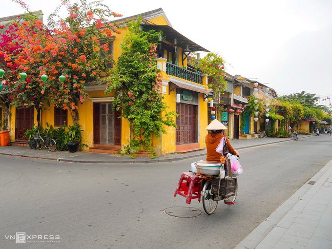 Khu vực ngã 3 đường Bạch Đằng – Trần Phú rực sắc màu hoa giấy, thỉnh thoảng có người bán hàng đạp xe qua phố vào sáng ngày 1/4.